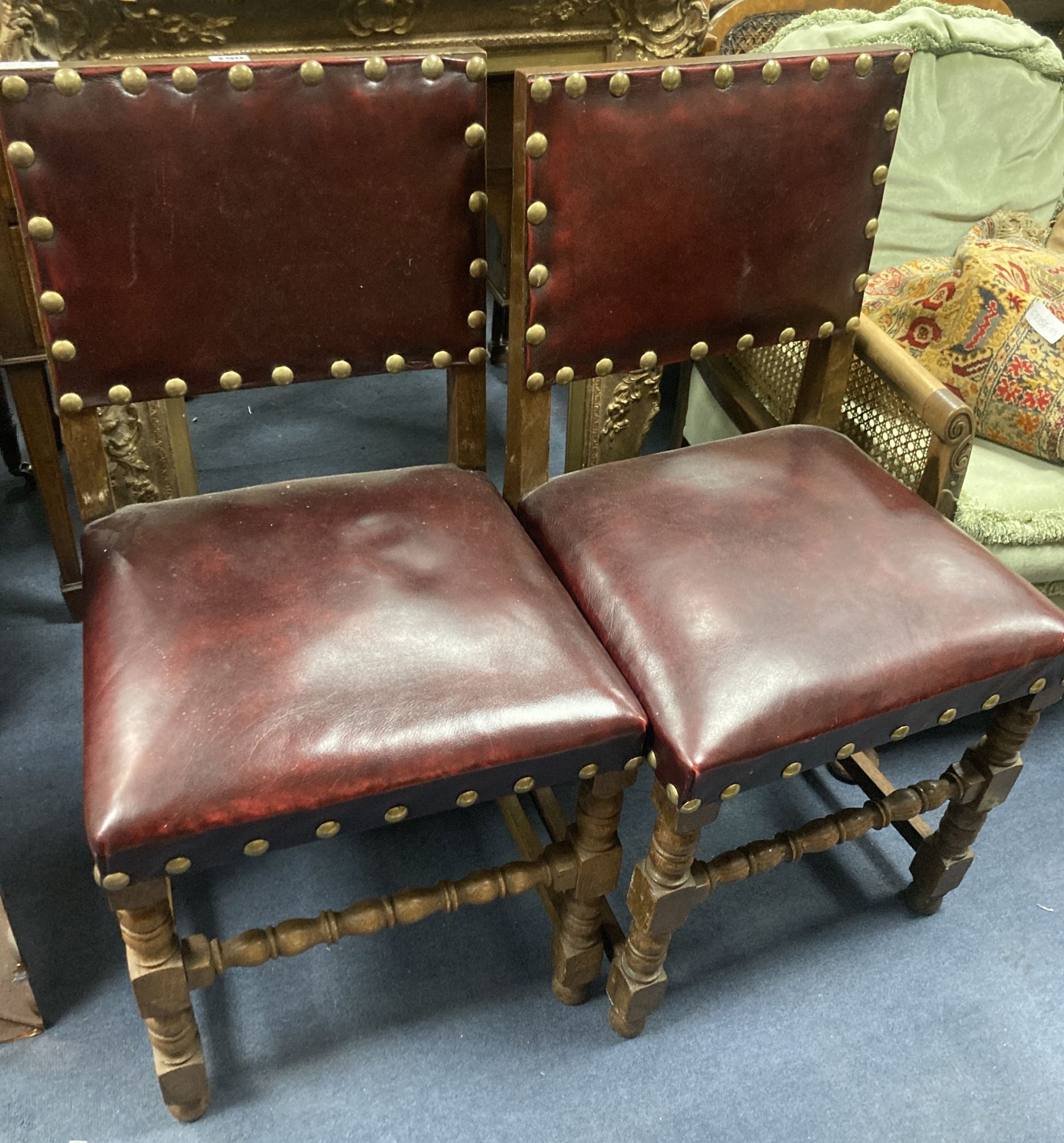 A pair of oak carolean-style dining chairs circa 1880, red leather and studding